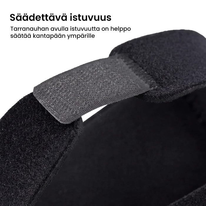 Mustat kantapääsuojat kantakannukseen, 1 pari. Suojassa on säädettävä tarranauha.